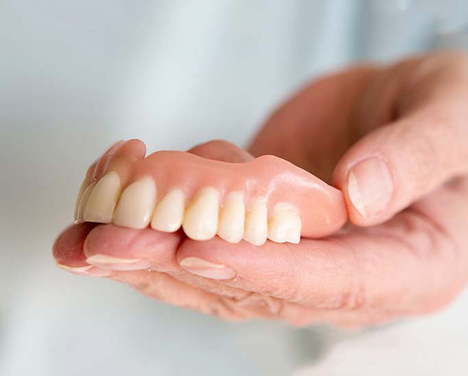 dentures in hand