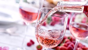 Close up of Rose wine being poured at a picnic setting.