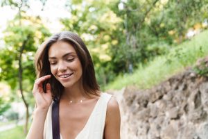 young woman smiling with braces and walking in the park