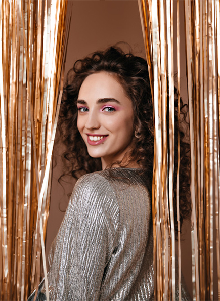girl smiling with veneers in gold background