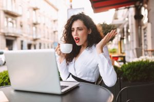young-shocked-lady-sitting-at-cafe-with-cup-of-coffee-research-on-porcelain-veneers
