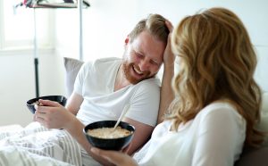 young-attractive-couple-having-breakfast-in-bed-while-husband-was-snoring-last-night